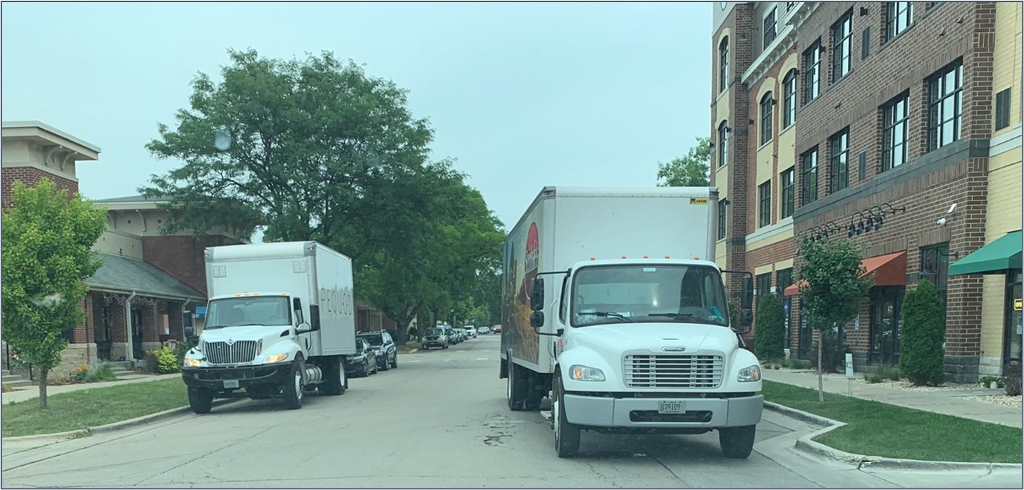 Delivery trucks parked on a city street.